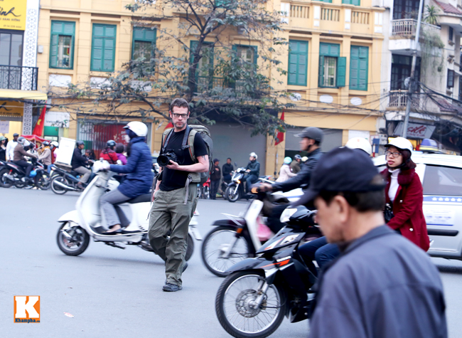 Một vị khách du lích mạo hiểm băng qua đường trước những làn xe máy đang phóng nhanh về phía mình.
