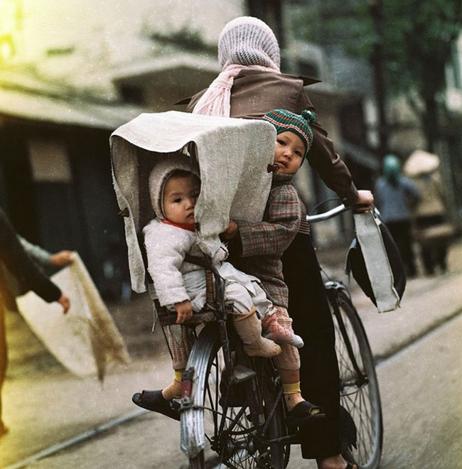Đến Việt Nam trong giai đoạn những năm 1960 - 1970, Thomas Billhardt đã ghi lại một cách chân thật, sống động cuộc sống thời kỳ chiến tranh chống Mỹ của người dân miền Bắc Việt Nam. Những hình ảnh khiến người xem xúc động mạnh. Trong ảnh, hai em bé được mẹ chở bằng xe đạp trên phố. Ánh mắt lạ lẫm của những em bé trước ống kính của nhiếp ảnh gia người Đức
