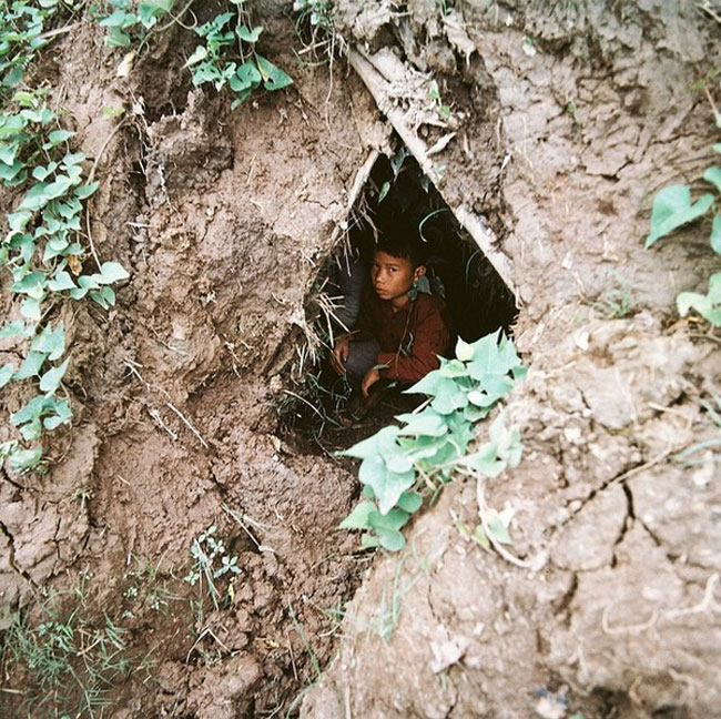 Bé trai đang trú ẩn trong đường hầm cạnh vách núi
