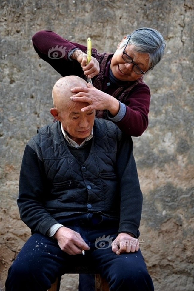Hình ảnh rất đẹp về người vợ đang cắt tóc cho chồng mình.
