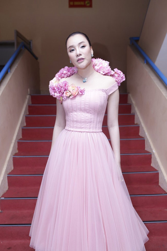 Nữ ca sĩ Hồ Quỳnh Hương trong một thiết kế màu hồng cầu kỳ với những chùm hoa làm điểm nhấn
