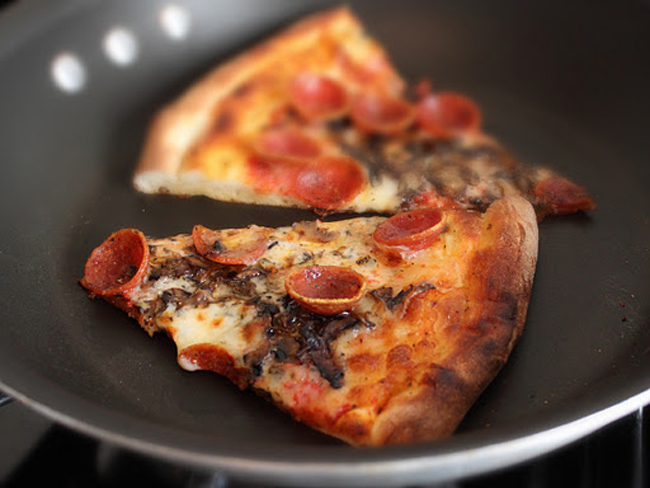 Nhà không có lò vi sóng? Gói bánh pizza vào giấy bạc và cho lên chảo. Bật lửa trung bình và sau một lúc, bạn sẽ có chiếc pizza nóng giòn đều các mặt.
