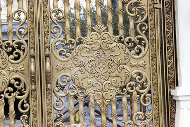  Những đường nét trên cánh cổng được thiết kế tinh xảo với chất liệu thép mạ đồng.
