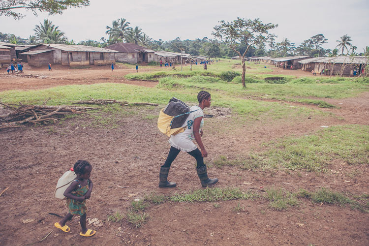 Christine và em gái 3 tuổi đang gánh thùng nước nặng trên lưng. Cuộc sống của những bà mẹ tuổi teen và cả những em bé ở Cameroon dường như không có tuổi thơ.
