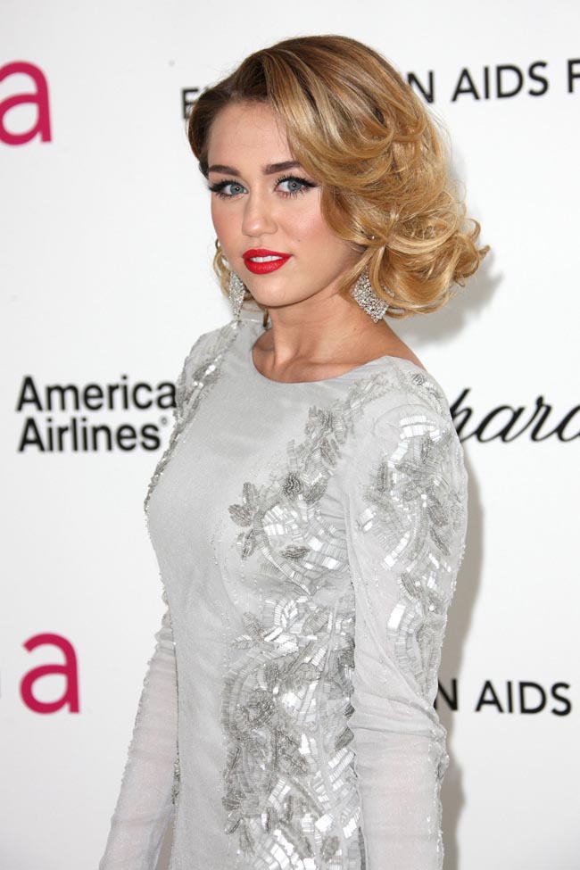 Miley Cyrus đẹp quý phái như phụ nữ tuổi 35. Kiêu tóc gợn sóng lệch, kết hợp đầm ánh bạc in hoa khiến cô hoàn toàn mất đi vẻ trẻ trung.
