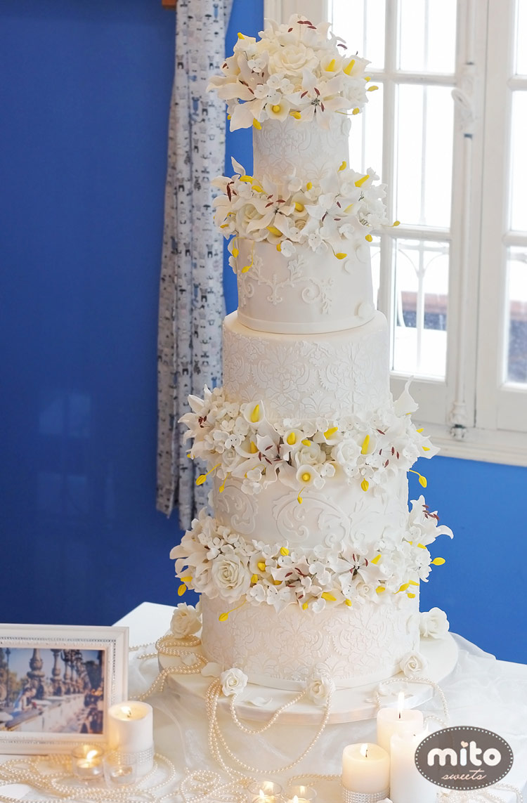 Một chiếc bánh cưới nhiều tầng cầu kì với các chi tiết hoa trang trí đẹp hút hồn.
