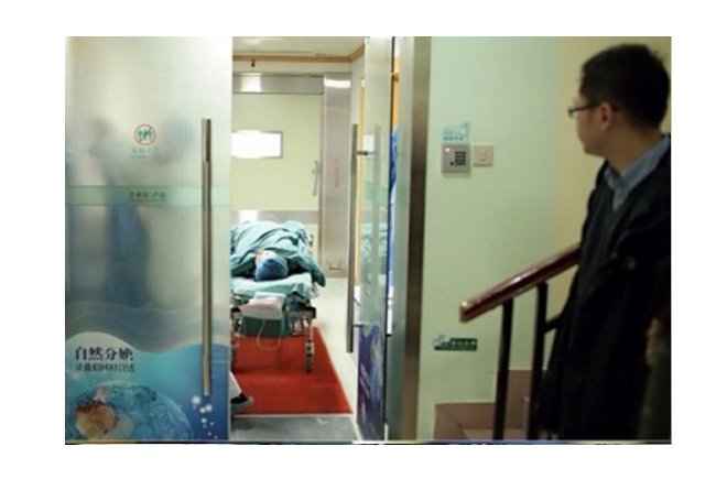 Cũng giống như nhiều bệnh viện ở Việt Nam, một số bệnh viện sản ở Trung Quốc cũng không cho phép người nhà có mặt trong phòng đẻ kể cả người chồng. Vì vậy chồng của sản phụ chỉ biết nhìn theo xe đẩy đưa vợ vào phòng sinh.
