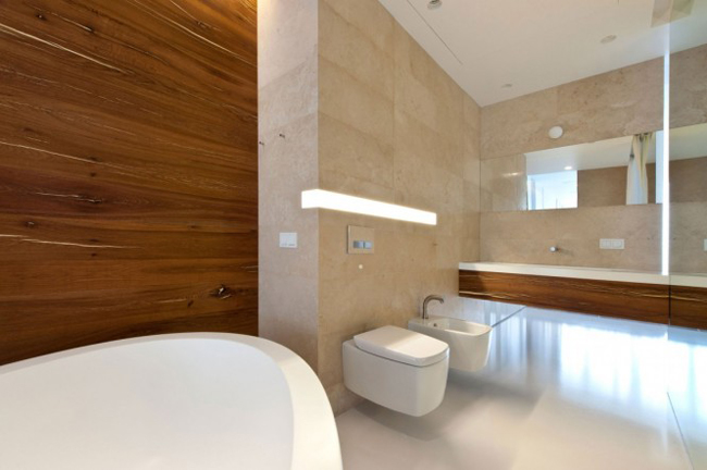 Chất liệu gỗ trên tường mang lại vẻ ấm áp cho phòng tắm rộng rãi.