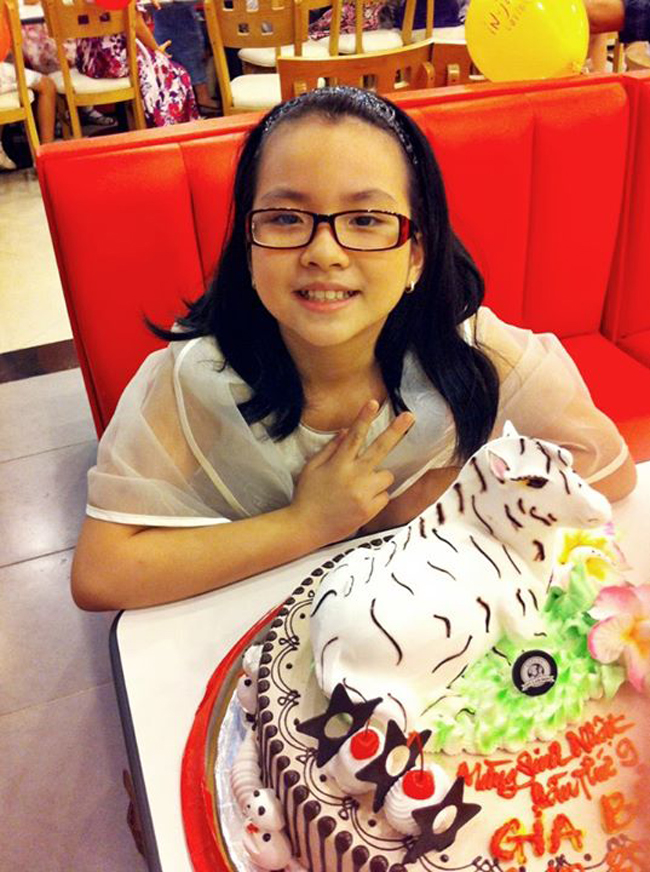 Tí Nị chụp ảnh bên chiếc bánh sinh nhật lần thứ 9 của mình.
