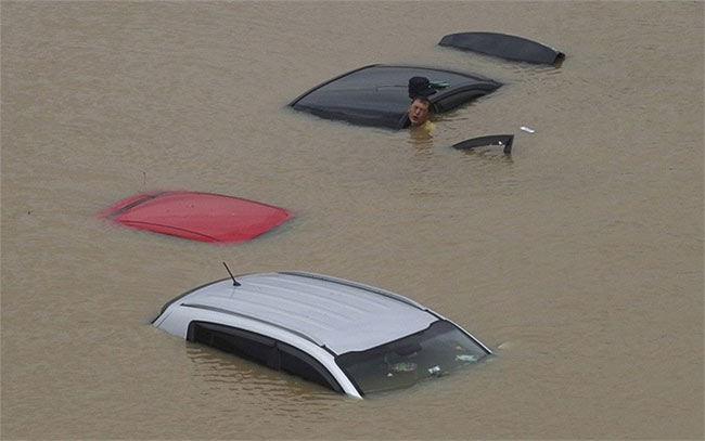 Người đàn ông cố gắng di chuyển chiếc xe bị ngập trong nước lũ sau khi mưa xối xả nhấn chìm khu vực trung tâm thủ đô Seoul, Hàn Quốc
