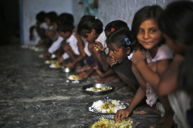 Các em học sinh ăn bữa trưa miễn phí tại một trường tiểu học ở làng Brahimpur, Chapra, bang Bihar (Ấn Độ), nơi mới đây vừa xảy ra vụ ngộ độc thức ăn làm chết 3 học sinh
