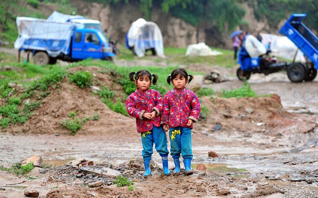 Hai chị em sinh đôi bên ngoài một khu lều tạm cho người dân sau vụ động đất ở huyện Minxian, Cam Túc (Trung Quốc). Theo cơ quan thông tấn nước này, có khoảng 94 người thiệt mạng, 1.000 người bị thương và hơn 51.800 ngôi nhà bị sập do ảnh hưởng của trận động đất này
