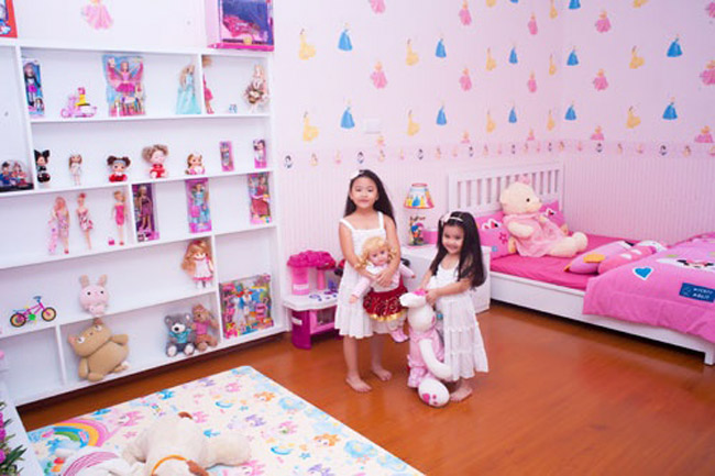Phòng của cô chị Lọ Lem đáng yêu như phòng của công chúa với màu hồng điệu đà. Cô bé còn có cả một kệ toàn búp bê barbie và thú bông.
