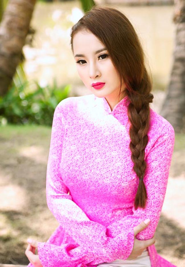 Diện áo dài hồng rực rỡ, tóc tết bím dễ thương, Phương Trinh rực rỡ trong nắng vàng.
