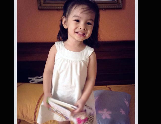 Cô con gái nhỏ nhà ông bầu Quang Huy có gương mặt tròn giống mẹ và đôi mắt hai mí to như bi ve.
