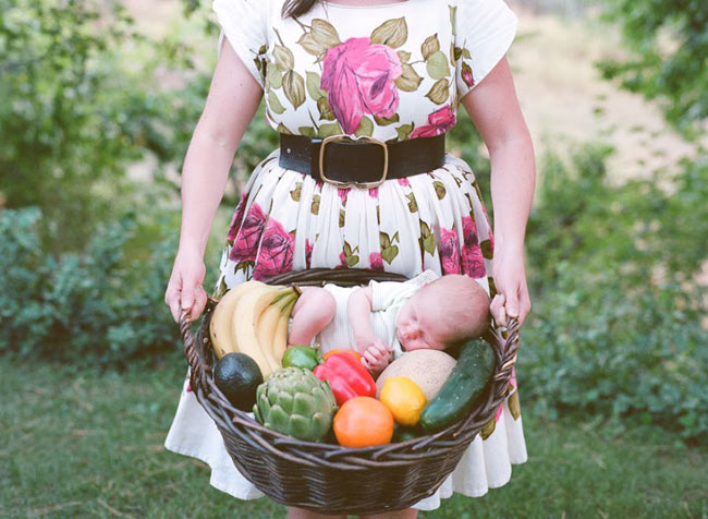 Bé chụp ảnh bên những loại trái cây mà mẹ đã dùng làm dụng cụ phụ đạo trong suốt bộ ảnh thai kỳ.
