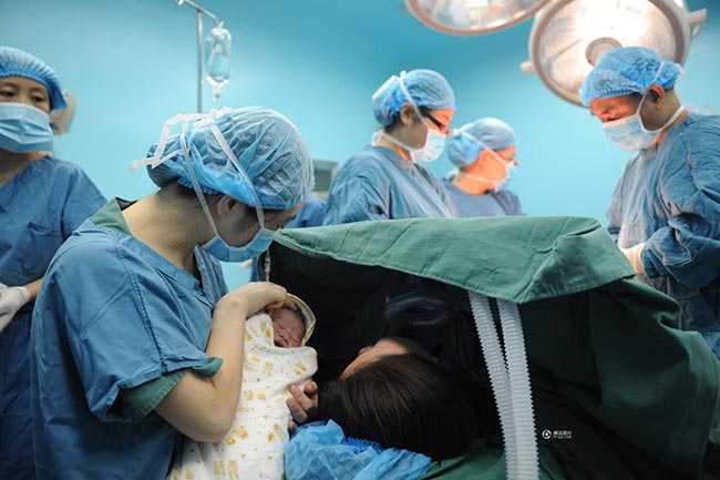 Trong khi các bác sỹ tiến hành khâu lại dạ con và bụng Guo Jia, cô đồng thời cũng được y tá cho xem mặt con. 
