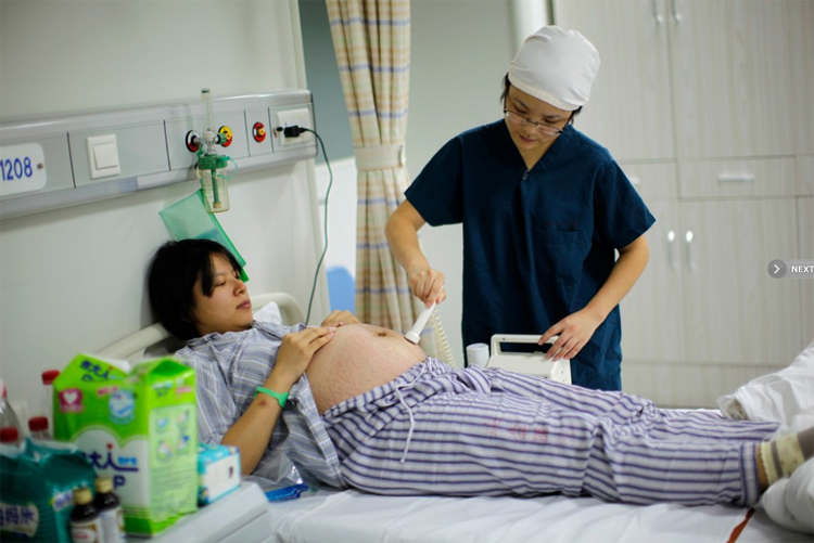 Một y tá đang kiểm tra thai cho sản phụ Yang Huiqing trước khi ca sinh mổ bắt đầu.
