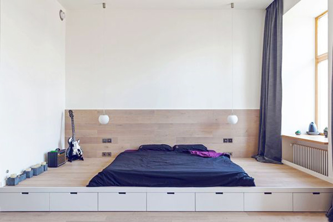 Đối diện với gian bếp là phòng ngủ. Có lẽ đây là phòng ngủ đơn giản nhất mà các bạn từng thấy. 'Căn phòng' được phân định bằng thiết kế độ can sao khác nhau. Hơn nữa, khoảng chênh lệch đó còn được tận dụng để bố trí hệ tủ kéo trữ đồ cực kỳ tiện lợi.
