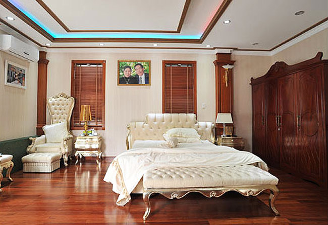 Phòng ngủ của bố mẹ chồng Trang Nhung mất điểm vì cách chọn đồ nội thất. Giường ngủ trắng muốt không ăn nhập với tủ quần áo, sàn gỗ, cột tường ốp gỗ màu nâu gụ. Và cả hệ thống đèn trần xanh gây nhức mắt vô cùng.
