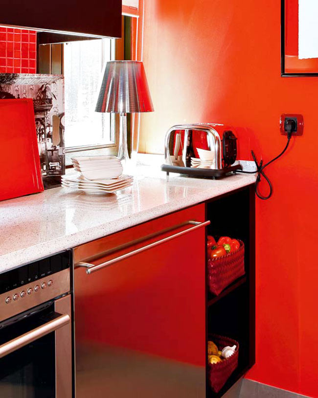 Phòng bếp có thiết kế chữ L cổ điển nhưng không thiếu đi nét hiện đại, tươi sáng nhờ bức tường bếp ốp gạch men màu đỏ tươi. Đây là cách sử dụng màu sắc khá táo bạo bởi lẽ màu đỏ là màu tràn đầy năng lượng, nếu không khéo léo sẽ rất dễ phản tác dụng.
