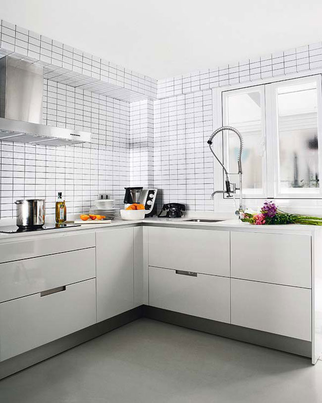 Bên cạnh bàn ăn là không gian nhỏ xinh của bếp được sắp xếp gọn gàng với hệ thống tủ bếp màu trắng. Bàn bếp thiết kế hình chữ U phù hợp và tiện dụng đối với không gian nhỏ. 

