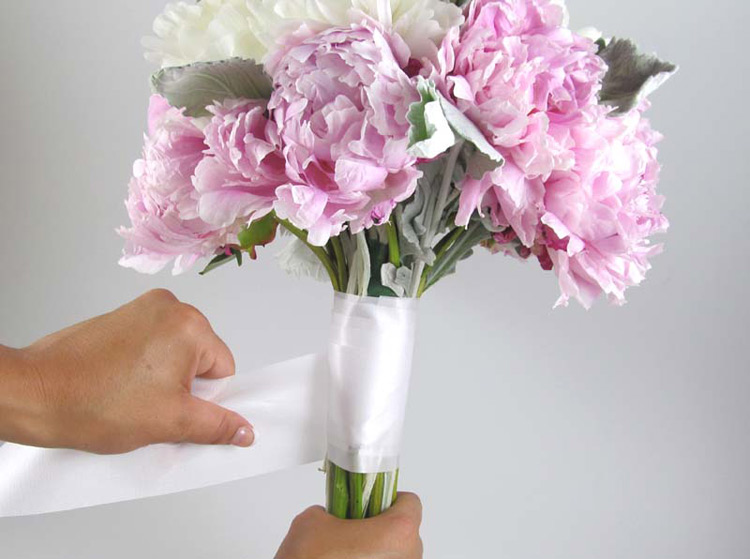 Cuốn ruy băng màu trắng kín phần thân bên dưới bó hoa.
