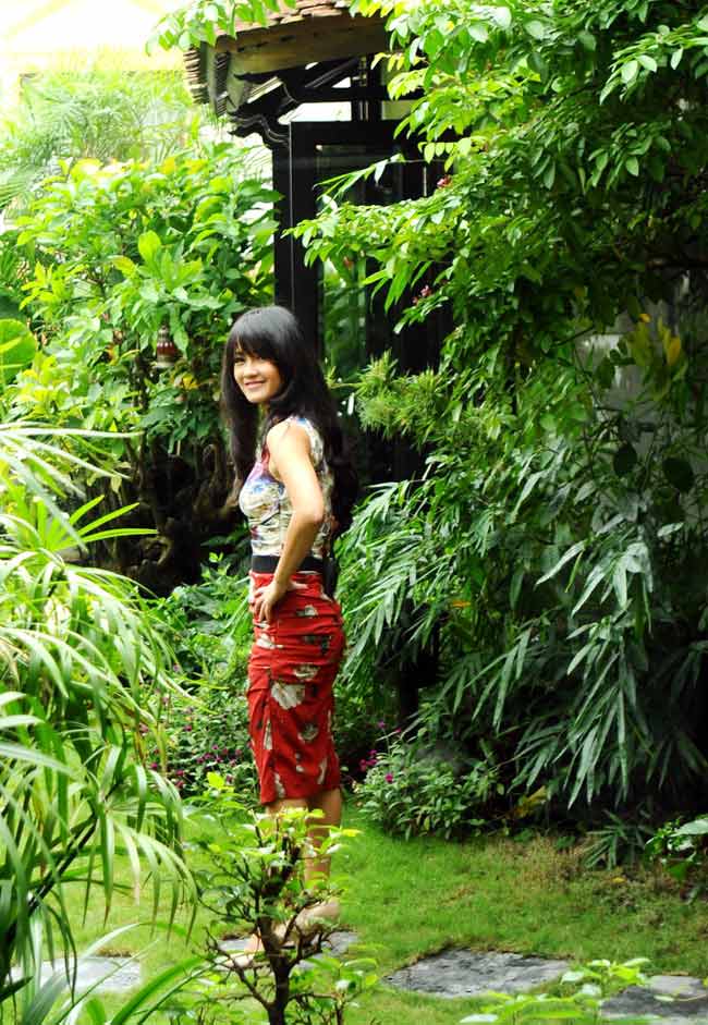 Hồng Nhung tạo dáng bên vườn nhà xanh ngợp mắt.
