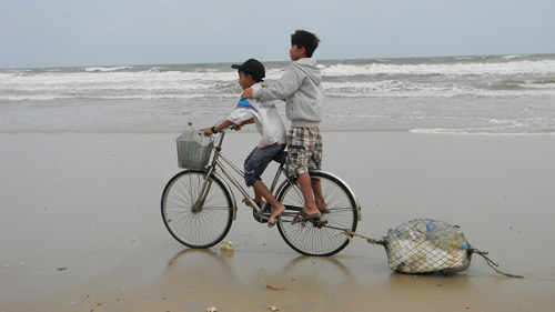 Trẻ nhỏ vật lộn với sóng biển để… lượm ve chai - 1