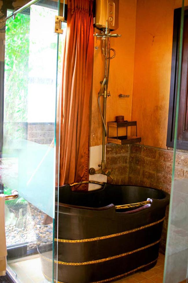Phòng tắm thiết kế khá cởi mở với những vách tường kính và rèm kéo. Bồn tắm gỗ gợi lại nét truyền thống rất ấn tượng.
