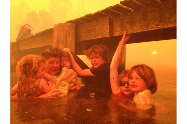 Bức ảnh được nhiếp ảnh gia Tim Holmes ghi lại cho thấy cảnh một bà mẹ và đàn con thơ dại sợ hãi ngâm mình dưới nước tránh lửa trong vụ cháy rừng kinh hoàng ở Tasmania, Australia ngày 4/1. Đây là vụ cháy rừng tồi tệ nhất trong lịch sử Australia đã khiến khoảng 100 người mất tích.
