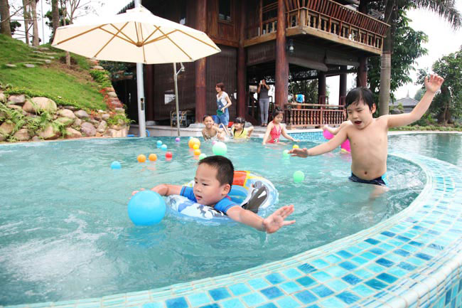 Bể bơi bên hông nhà sàn dành cho trẻ nhỏ vui chơi vào dịp hè.
