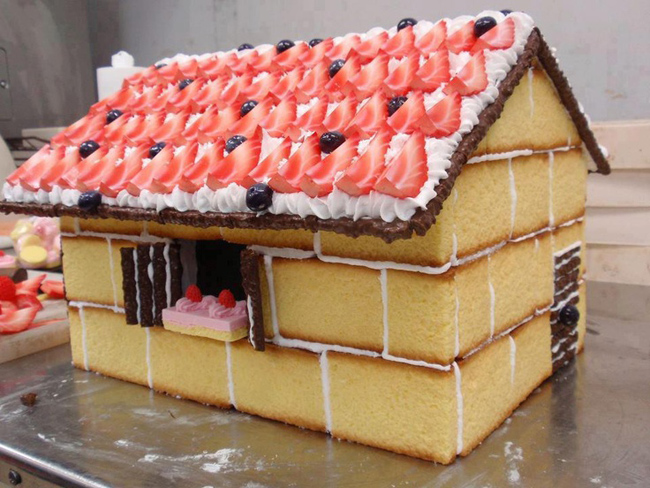Một ngôi nhà bánh ngọt với mái che là kem tươi, sô cô la và dâu tây.

