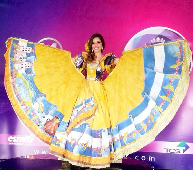 Hoa hậu El Salvador, Larissa Vega mặc một bộ trang phục truyền thống của người El Salvador được in hình quốc kỳ và những nét đặc trưng của quốc gia như núi lửa hay nhà thờ.

