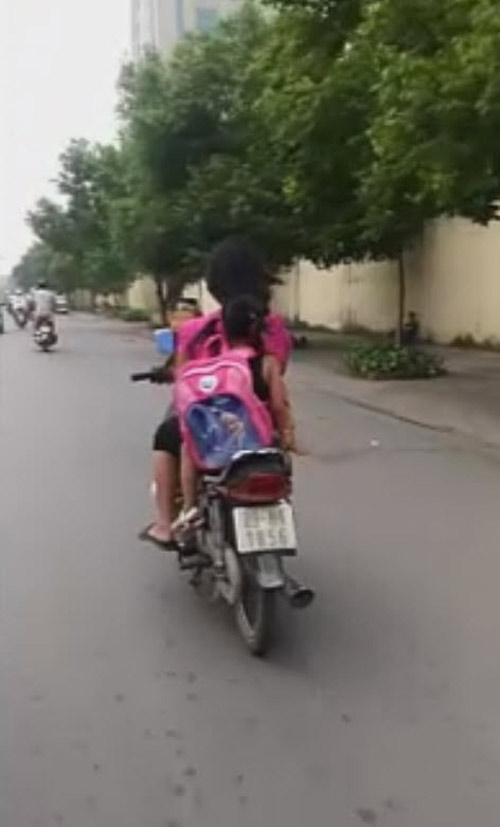 Bà mẹ liều nhất năm: một tay đi xe máy đèo 3 đứa trẻ, một tay bế cho con bú - 1