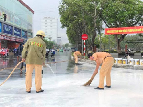 CSGT dầm mưa giúp người dân quét sơn bị đổ ra đường - 1