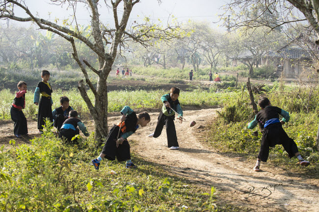 Các cậu bé người Mông thích thú chơi con quay trong ngày Tết truyền thống.
