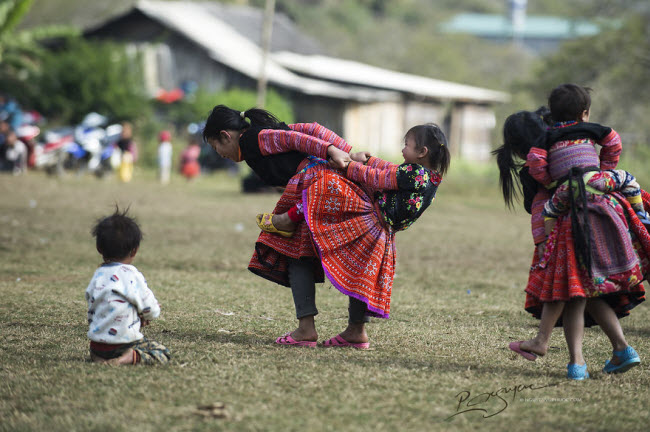 Những đứa trẻ thích thú chơi đùa với nhau trên bãi cỏ rộng. 
