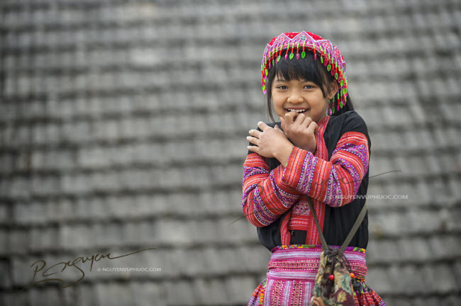 Nụ cười hồn nhiên của bé gái trong trang phục truyền thống của người Mông trong ngày Tết.
