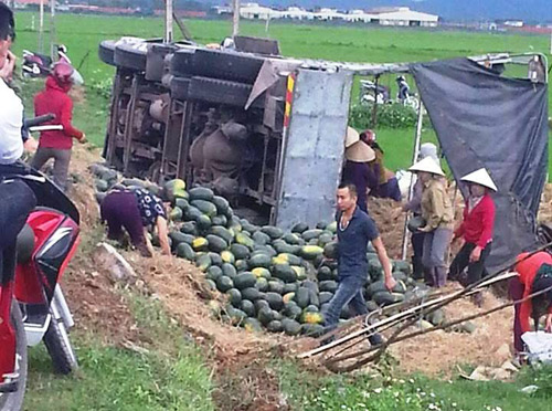 20 tấn dưa hấu đổ tràn ra đường sau cú lật xe tải, người dân xúm vào nhặt giúp tài xế - 1
