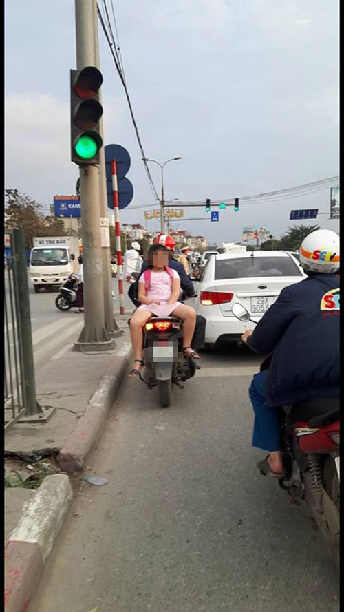 Người đi đường hoảng hốt với ông bố để con gái nhỏ ngồi ngược phía sau xe máy - 1