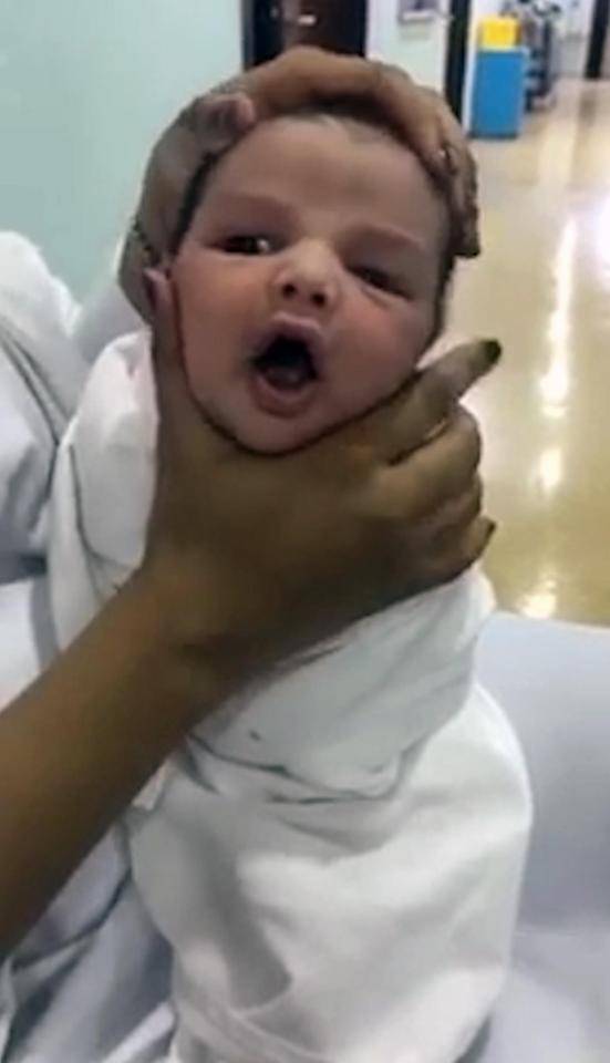 Nữ y tá vừa cười khúc khích vừa ấn đầu, bóp má trẻ sơ sinh đến biến dạng - 1