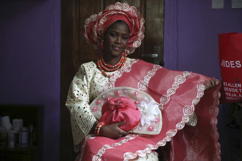 Cô dâu Nigeria nổi bật với áo choàng trang trí tỉ mỉ và mấn to trên đầu.


