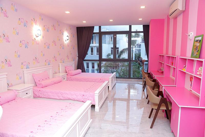 Phòng ngủ của 3 cô con gái mang tông hồng ngọt ngào. Các bé được bố mẹ sắm giường, bàn học và tất cả vật dụng giống hệt nhau.
