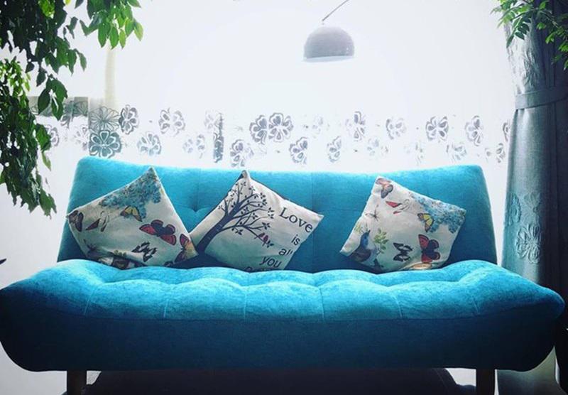 Ghế sofa xanh trên rèm trắng tạo cảm giác thư thái, nhẹ nhàng.
