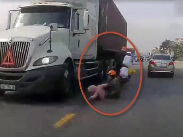 Bị ô tô quệt văng xuống đường, mẹ nhanh trí cứu con thoát khỏi bánh container