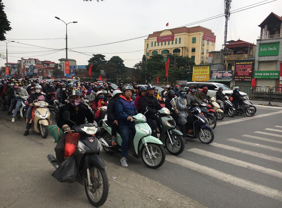 Một số người dân trở lại Thủ đô Hà Nội bằng phương tiện xe máy. Trong ảnh, người dân đứng chờ đèn tín hiệu giao thông tại đường Giải Phóng.