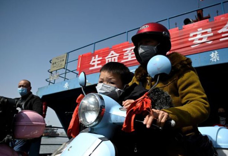 Hai mẹ con tại tỉnh Hồ Bắc, Trung Quốc đeo khẩu trang cẩn thận trước khi ra đường hôm 14/3. Nơi đây là khu vực chịu ảnh hưởng nặng nề nhất của dịch bệnh.
