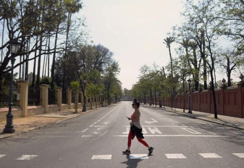 Một người phụ nữ chạy qua con đường vắng lặng ở thành phố Seville, Tây Ban Nha hôm 14/3. Thành phố này đã phải hủy bỏ lễ rước kiệu Holy Week nổi tiếng vì dịch COVID-19.
