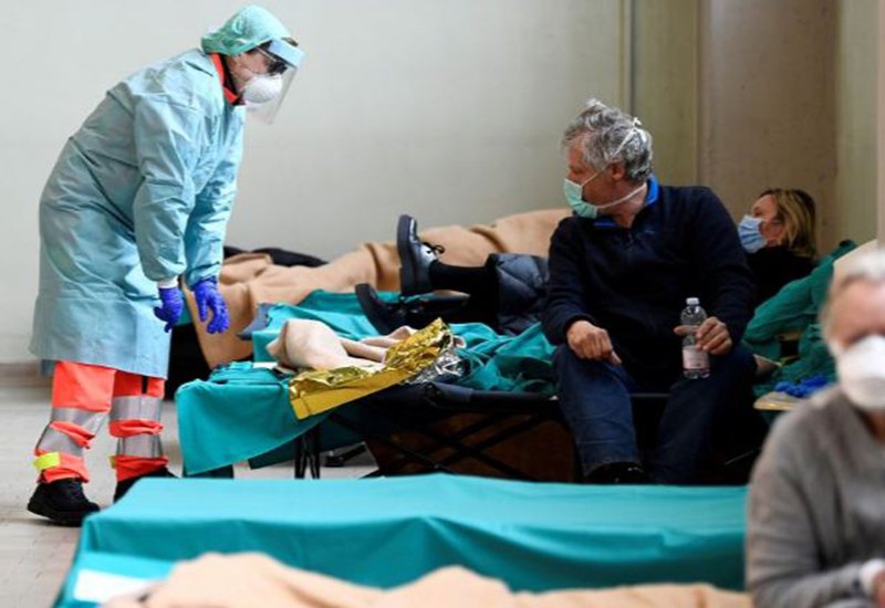 Nhân viên y tế đang giúp đỡ một bệnh nhân lớn tuổi trong Bệnh viện Spedali Civili, thuộc thành phố Brescia, nước Ý  hôm 13/3.
